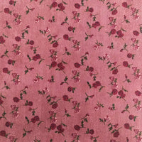 The 8 Wales Floral Corduroy Fabric by Longan Craft features a pink base with scattered small roses and green leaves, in shades of pink and red—a vintage-inspired choice for DIY clothes or home decor. Available by the yard.
