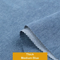 Close-up of thick, medium blue Longan Craft Cotton Denim Fabric by the Yard with a folded corner showing texture and edge details—perfect for dressmaking projects; labeled "Thick Medium Blue" on a yellow tag.