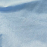 A close-up of Longan craft’s Light Weight Plain Ramie Fabric by the yard, 54" wide in soft pale blue, shows fine weave details and gentle shading across its breathable, sustainable cotton blend—ideal for dresses or curtains.