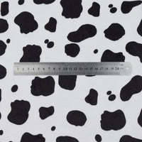 A silver 20cm ruler rests on Longon Craft's Animal Patterned Minky Fabric By The Yard, featuring a leopard dot cow pattern printed on plush white polyester, ideal for plushies and crafts.