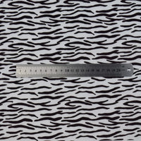 A Longon Craft metal ruler measuring up to 20 cm lies on animal patterned minky fabric by the yard, featuring a leopard dot cow print cuddle material for plushies from their Floral Minky Fabric collection.