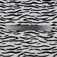 A 20-centimeter metal ruler is placed on Longon Craft’s Animal Patterned Minky Fabric By The Yard, featuring a Leopard Dot Cow Pattern Printed Minky Material, resembling floral cuddle minky fabric for plushies.