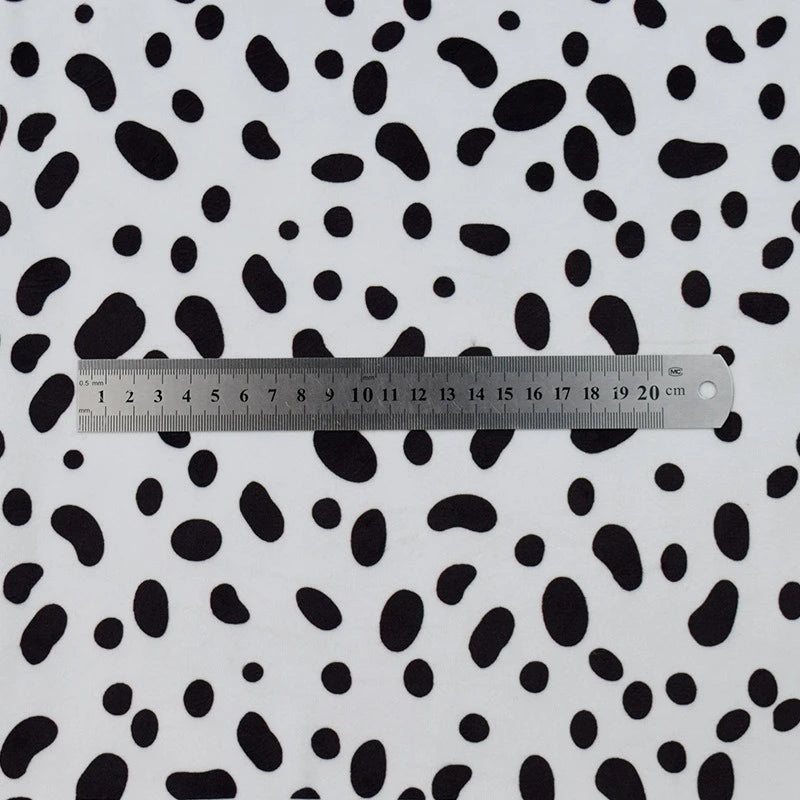 A silver 20cm ruler rests on Longon Craft's Animal Patterned Minky Fabric By The Yard, featuring a leopard dot cow pattern printed minky material that resembles cuddly, plush floral fabric.
