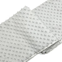 A folded piece of Longon Craft Dotted Minky Fabric By The Yard features a plush light gray surface with evenly spaced 3D dots, perfect for DIY craft sewing and projects.