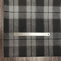 A metal ruler lies horizontally on Longon Craft Polyester Cotton Plaid Flannel Fabric By The Yard, displaying centimeter measurements from 1 to 15.