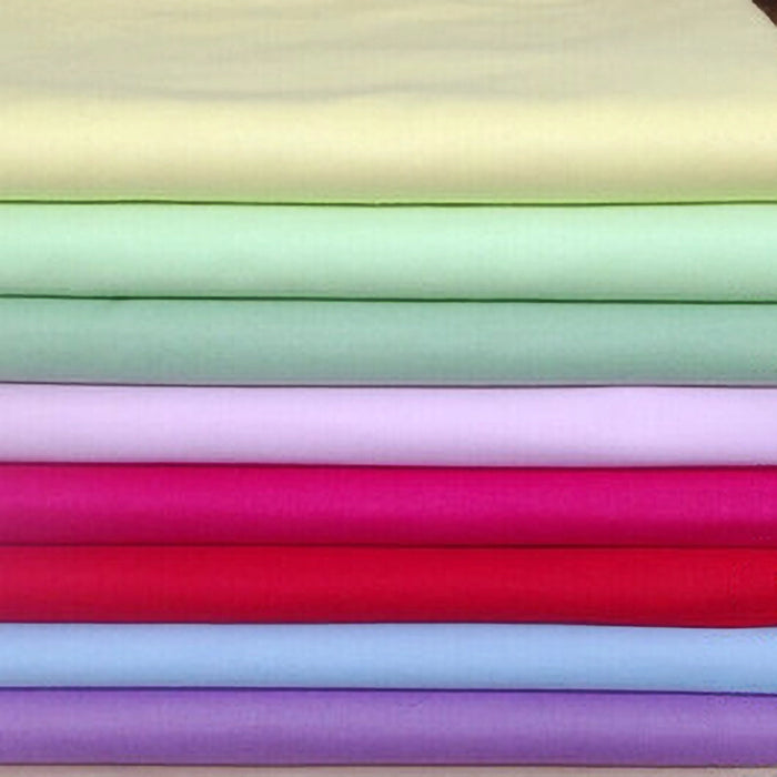 A stack of Longan craft Stretch Poplin Fabric By The Yard in pastel and bright shades—yellow, green, pink, lavender, red, blue, purple—perfect lightweight cotton stretch poplin material for apparel or quilting projects.