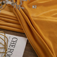 A folded piece of mustard yellow Longon Craft Stretch Minky Fabric By The Yard, labeled 82, rests beside a magazine partially showing the word "CHEFOOD.