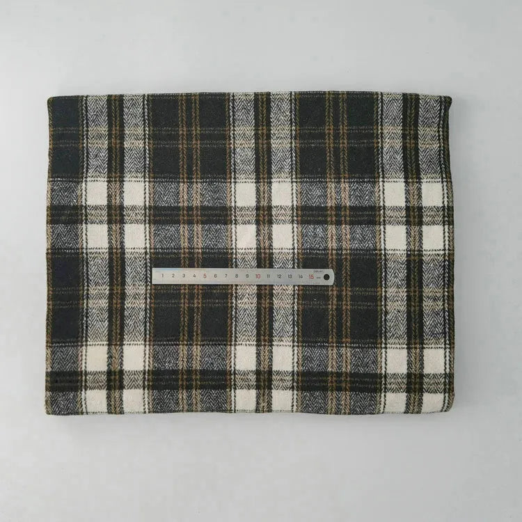 A piece of Multicolor Plaid Mammoth Flannel Fabric by Longan Craft, a brushed polyester-cotton textile ideal for shirts, is folded on a light surface with a metal ruler across its center for scale.