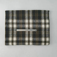 A piece of Multicolor Plaid Mammoth Flannel Fabric by Longan Craft, a brushed polyester-cotton textile ideal for shirts, is folded on a light surface with a metal ruler across its center for scale.