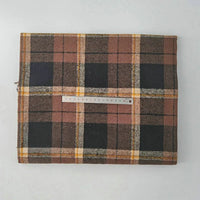 A piece of Longan Craft Multicolor Plaid Mammoth Flannel Fabric by the yard is folded on a white surface, with a ruler across it to show its width. This brushed polyester cotton flannel is ideal for comfy shirts.