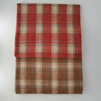 Two folded blankets made from Longan Craft's Multicolor Plaid Mammoth Flannel Fabric, a cozy brushed polyester cotton material, are stacked on a white surface. The top is red plaid with beige/gray lines; the bottom is brown plaid.