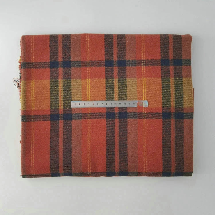 A folded piece of Longan Craft Multicolor Plaid Mammoth Flannel Fabric by the yard with a clear ruler in centimeters on top rests on a plain white surface. This soft, brushed polyester-cotton textile is ideal for shirts.
