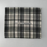 A piece of Longan Craft Multicolor Plaid Mammoth Flannel Fabric By The Yard lies folded on a flat surface, displaying its black, white, and gray brushed polyester cotton material with a clear ruler on top for scale.