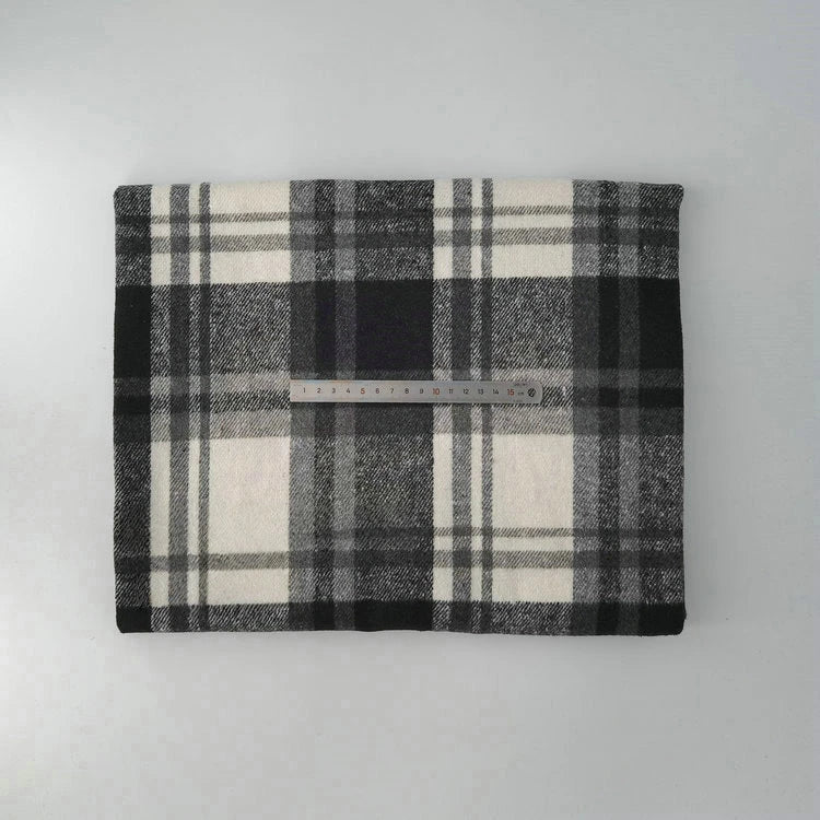 A piece of Longan Craft’s Multicolor Plaid Mammoth Flannel Fabric by the yard, a comfy brushed polyester-cotton blend for shirts, is folded on a light surface with a ruler across its center to show width.