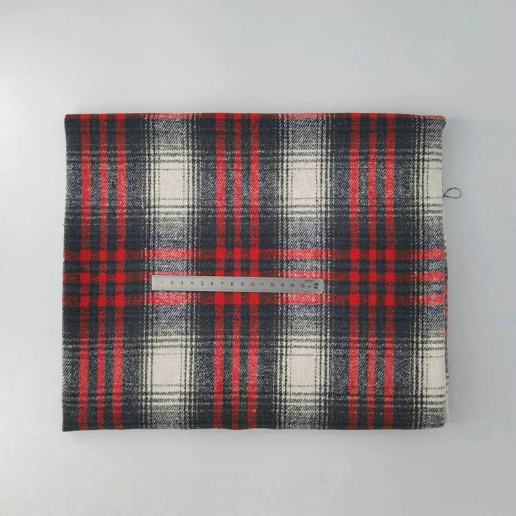 A piece of Longan Craft Multicolor Plaid Mammoth Flannel Fabric By The Yard is laid flat on a white surface, showing its red, black, and white brushed polyester cotton pattern with a ruler across the center for scale.