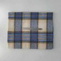 A piece of Longan Craft Multicolor Plaid Mammoth Flannel Fabric by the yard lies flat on a white surface with a metal ruler on top for scale. The comfy brushed polyester-cotton flannelette is ideal for shirts.