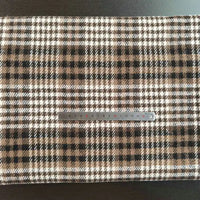 A piece of Multicolor Plaid Mammoth Flannel Fabric by Longan Craft lies flat with a silver measuring tape across it, showcasing the soft brushed polyester cotton textile perfect for shirts.