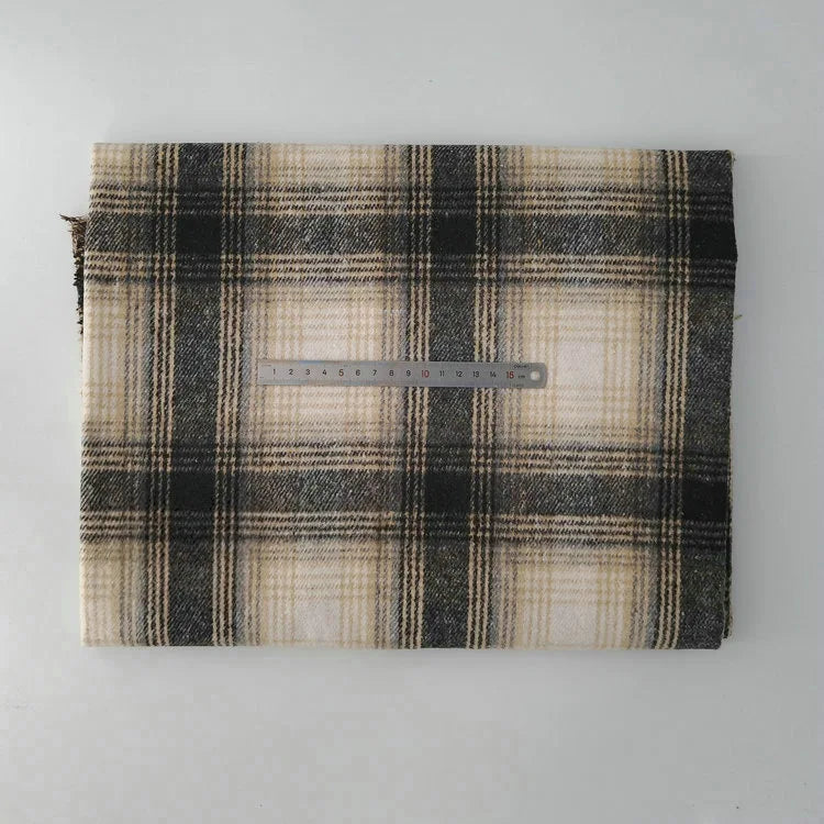 A piece of Longan Craft Multicolor Plaid Mammoth Flannel Fabric by the yard rests folded next to a metal ruler on a white background, showing the comfy brushed polyester cotton textile’s scale and striped design.