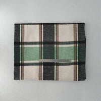 The Multicolor Plaid Mammoth Flannel Fabric by Longan Craft is shown folded with large black, white, brown, and green checks. A center ruler shows scale. This brushed polyester cotton flannel is displayed on a light gray background.