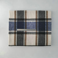 Multicolor Plaid Mammoth Flannel Fabric by the yard from Longan Craft, featuring black, brown, blue, and white stripes, is shown folded with a clear ruler for scale on a light background. Brushed polyester-cotton flannelette for shirts.