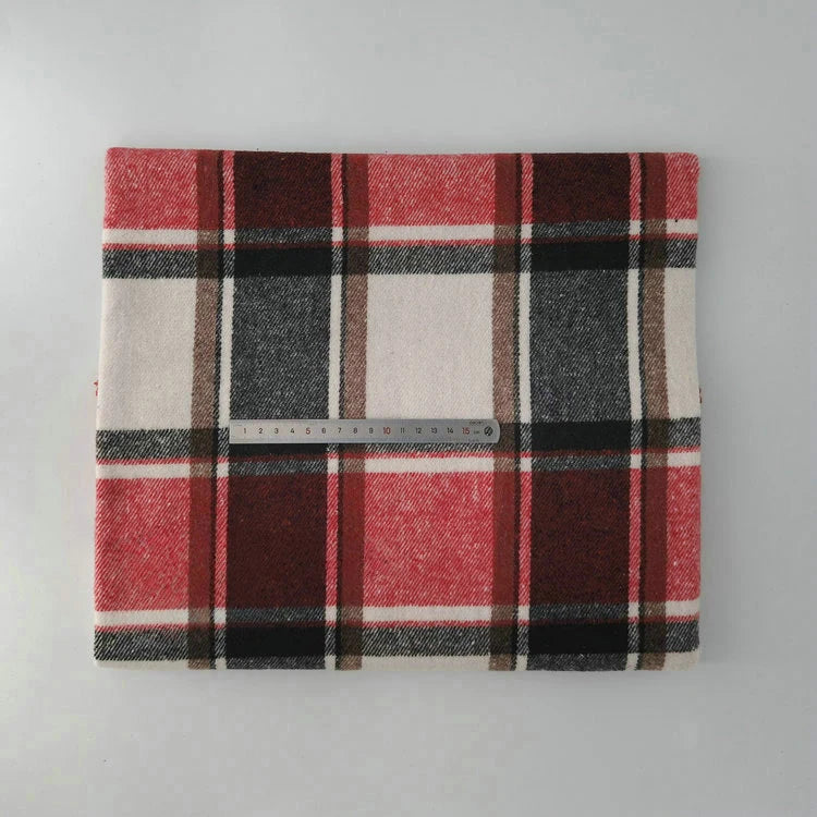 The Multicolor Plaid Mammoth Flannel Fabric by Longan Craft is a red, black, brown, and white brushed polyester cotton textile for shirts, shown folded with a ruler on a light gray surface.