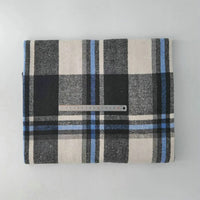 A piece of Longan Craft Multicolor Plaid Mammoth Flannel Fabric by the yard, featuring black, white, gray, and blue stripes, is displayed folded on a flat surface with a clear ruler on top to show its size.