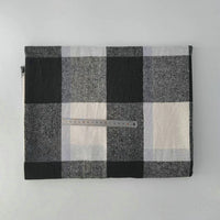 A folded Longan Craft Multicolor Plaid Mammoth Flannel Fabric by the yard lies on a light surface with a transparent ruler across the center, displaying the scale of this comfy brushed polyester cotton textile for shirts.