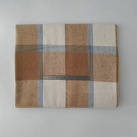 A folded Longan Craft Multicolor Plaid Mammoth Flannel Fabric by the yard rests on a light gray surface, with a metal ruler placed across the brushed polyester cotton textile for scale.