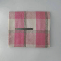 A folded Longan Craft Multicolor Plaid Mammoth Flannel Fabric is laid flat, displaying its pink, cream, and gray pattern. A black ruler rests across the brushed polyester-cotton material for scale. Ideal comfy flannelette for shirts, sold by the yard.