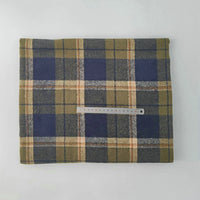 A piece of Multicolor Plaid Mammoth Flannel Fabric By The Yard from Longan Craft, in olive green, navy blue, and beige stripes, is folded on a white surface with a 15-cm ruler on top to show scale.