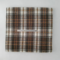 A piece of Longan Craft Multicolor Plaid Mammoth Flannel Fabric, a comfy brushed polyester cotton flannelette for shirts, is shown folded with brown, black, and white lines and a 30cm ruler on top for scale.