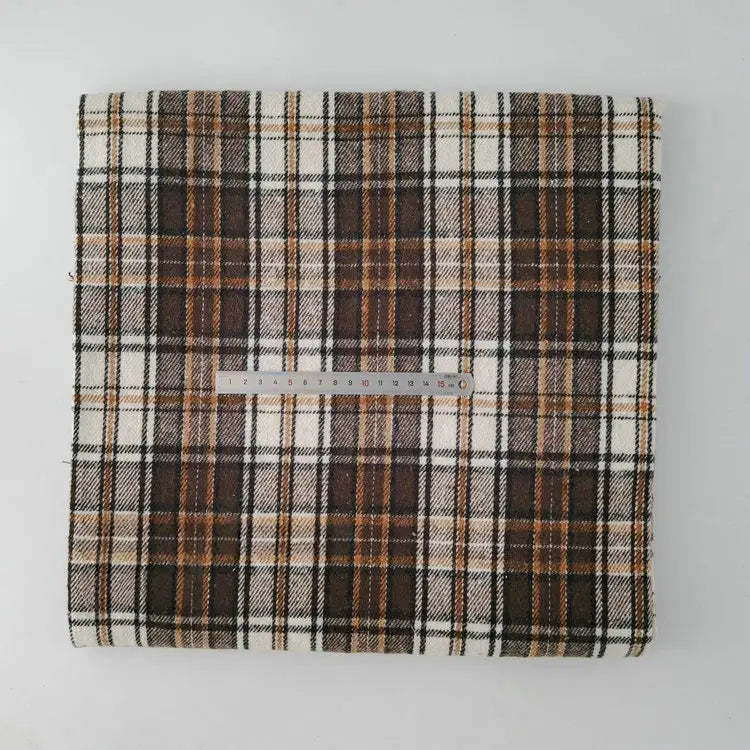 A piece of Longan Craft Multicolor Plaid Mammoth Flannel Fabric, a comfy brushed polyester cotton flannelette for shirts, is shown folded with brown, black, and white lines and a 30cm ruler on top for scale.