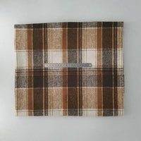 A piece of Longan Craft Multicolor Plaid Mammoth Flannel Fabric by the yard is displayed on a white surface with a metal ruler for scale, showing its brown, beige, and cream checked brushed polyester cotton flannelette.