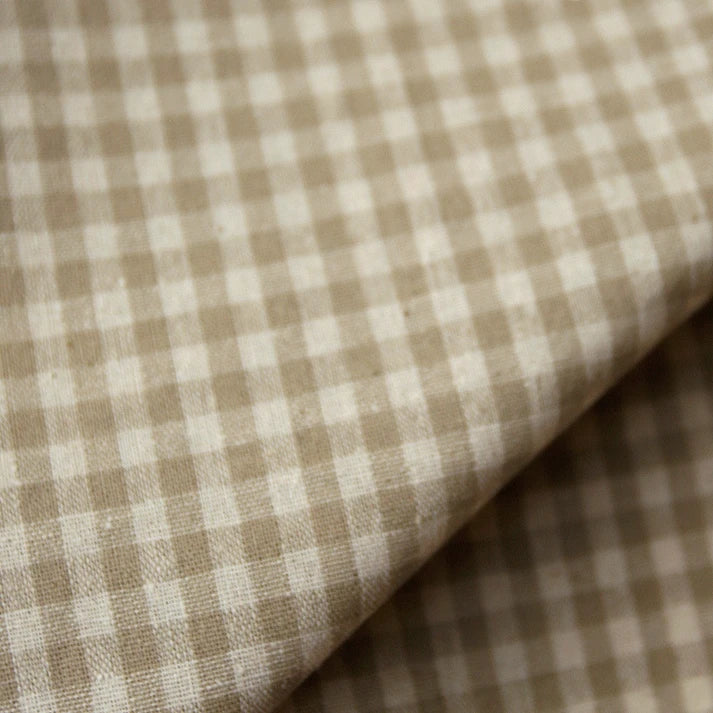Close-up of Longan Craft’s 100% cotton gingham poplin fabric, showcasing its premium soft texture and lightweight appearance. The multicolor yarn-dyed checkered pattern in beige and white is clearly visible, with the fabric slightly folded to reveal its high-quality poplin material—ideal for garment making.