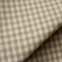 Close-up of Longan Craft’s 100% cotton gingham poplin fabric, showcasing its premium soft texture and lightweight appearance. The multicolor yarn-dyed checkered pattern in beige and white is clearly visible, with the fabric slightly folded to reveal its high-quality poplin material—ideal for garment making.