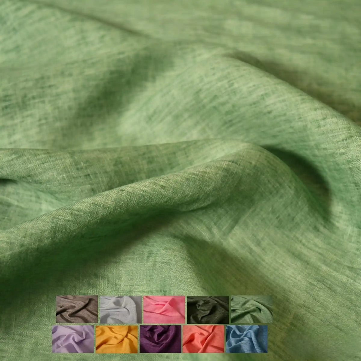 A soft, light green 100 Linen Fabric By The Yard from Longan Craft is draped in gentle folds, with twelve small solid color lightweight linen swatches—including brown, pink, yellow, purple, and blue—displayed in the lower left corner.