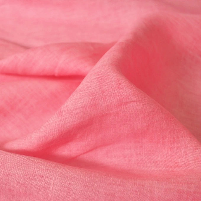 A close-up of Longan Craft’s 100 Linen Fabric By The Yard shows soft, pink, lightweight linen with a visible weave and gentle folds—perfect as a comfortable summer linen material.