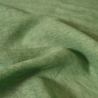 A close-up of Longan Craft’s 100% linen fabric by the yard showcases its light green color, lightweight and textured weave, with soft folds creating gentle shadows—ideal for comfortable summer projects.