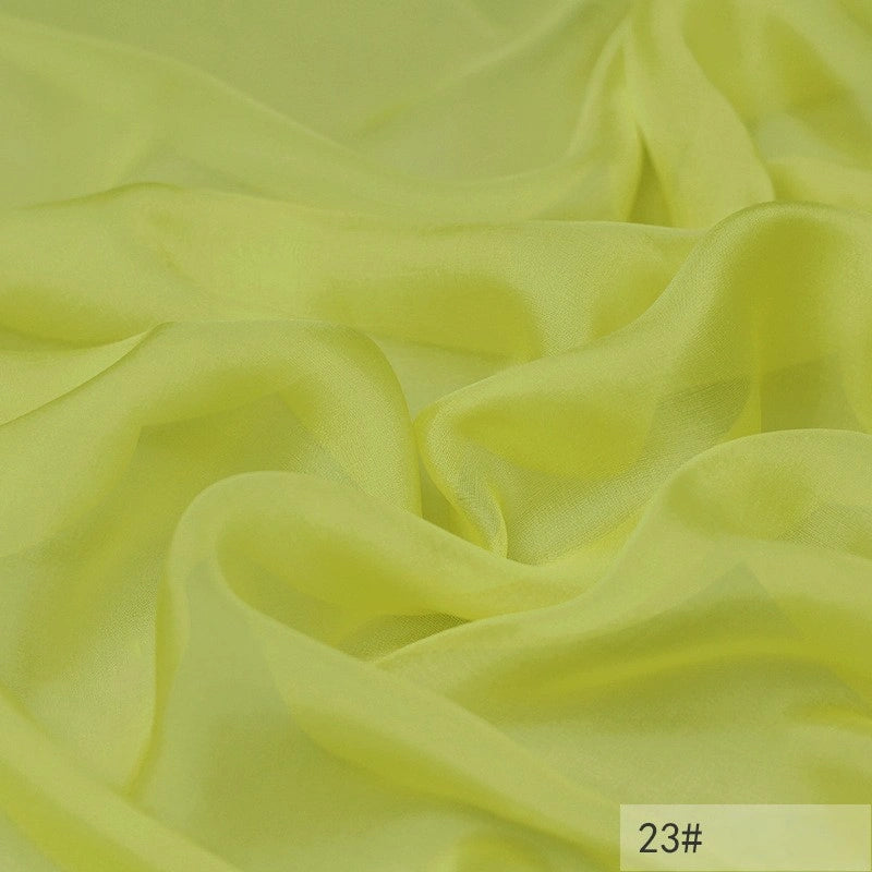 Light yellow, semi-transparent 100 Mulberry Silk Chiffon Fabric by Longan Craft with soft folds and smooth texture, perfect for dresses. The bottom right corner shows the label 23#.