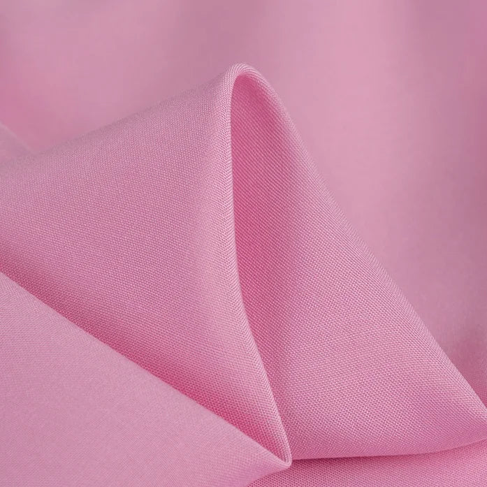 A close-up of Longan Craft’s 100% rayon fabric by the yard in solid light pink, showing its silky-smooth texture, gentle drape, and subtle sheen—ideal soft viscose clothing material for dressmaking.