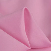 A close-up of Longan Craft’s 100% rayon fabric by the yard in solid light pink, showing its silky-smooth texture, gentle drape, and subtle sheen—ideal soft viscose clothing material for dressmaking.