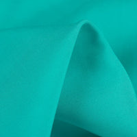 A close-up of Longan Craft's 100% Rayon Fabric by the Yard in teal showcases its silky-smooth texture, soft folds, and vibrant color—ideal for dressmaking and viscose clothing projects.