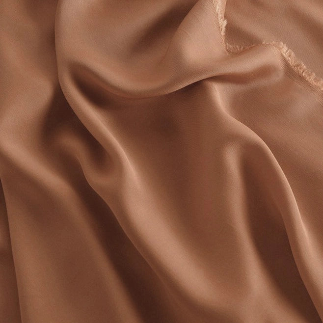 A close-up of Longan Craft’s 100 Rayon Fabric by the Yard shows its light brown, silky viscose material with soft folds, slightly sheer texture, subtle sheen, and smooth drape—ideal for breathable dressmaking projects.