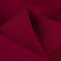 Close-up of smooth, folded maroon 100% rayon fabric by Longan Craft, featuring a solid color and subtle sheen. This soft viscose dressmaking textile is perfect for clothing projects and is available by the yard.