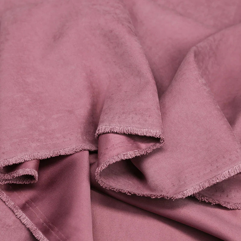 A close-up of Longan Craft's Multi Color Microsuede Polyester Peachskin Fabric shows its soft, brushed texture and gentle folds, highlighting the cozy sheen—ideal for clothing and available by the yard.