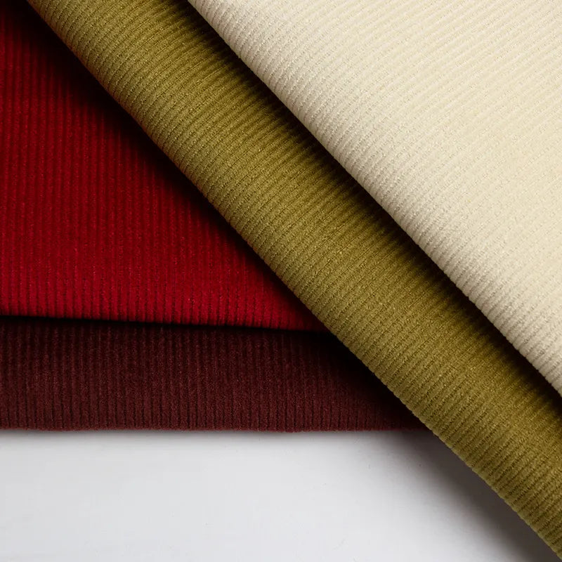 Three pieces of Longan Craft's 11 Wales Cotton Corduroy Fabric by the Yard in cream, olive green, red, and brown are layered diagonally, displaying the rich ribbed texture of this thick 100% cotton corduroy ideal for apparel.