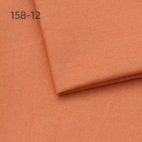 Two pieces of Longan Craft Faux Linen Upholstery Fabric (158-12) in light brown or terracotta are stacked and neatly folded. The polyester fabric features a fine, even weave—ideal for upholstering chairs, sofas, or curtains.