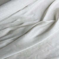 A close-up of Longan Craft's 14 Momme Linen Silk Fabric By The Yard reveals soft, smooth folds and subtle shadows—this vibrant organza mulberry silk is ideal for summer projects.