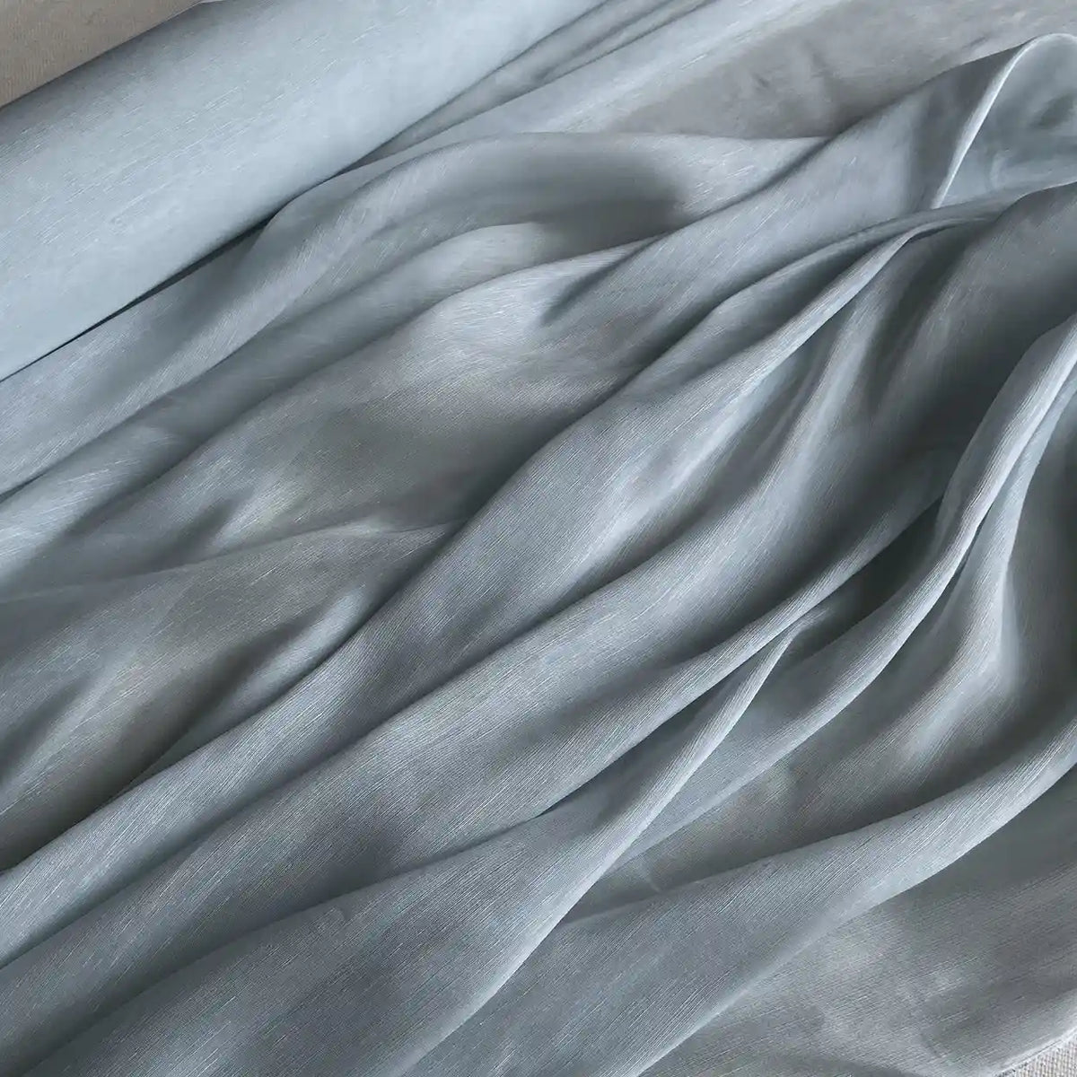 Longan Craft's 14 Momme Linen Silk Fabric By The Yard is a lightweight, smooth organza mulberry silk with a subtle sheen. Ideal for summer, the airy material drapes in gentle folds, highlighting its flowing lines and vibrant texture.