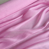 Close-up of 14 Momme Linen Silk Fabric by the yard from Longan Craft, a vibrant Organza Mulberry Silk material in soft light pink, showing gentle folds and drapes—ideal for summer projects.